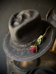 Distressed rock and roll hat with a skull and rose